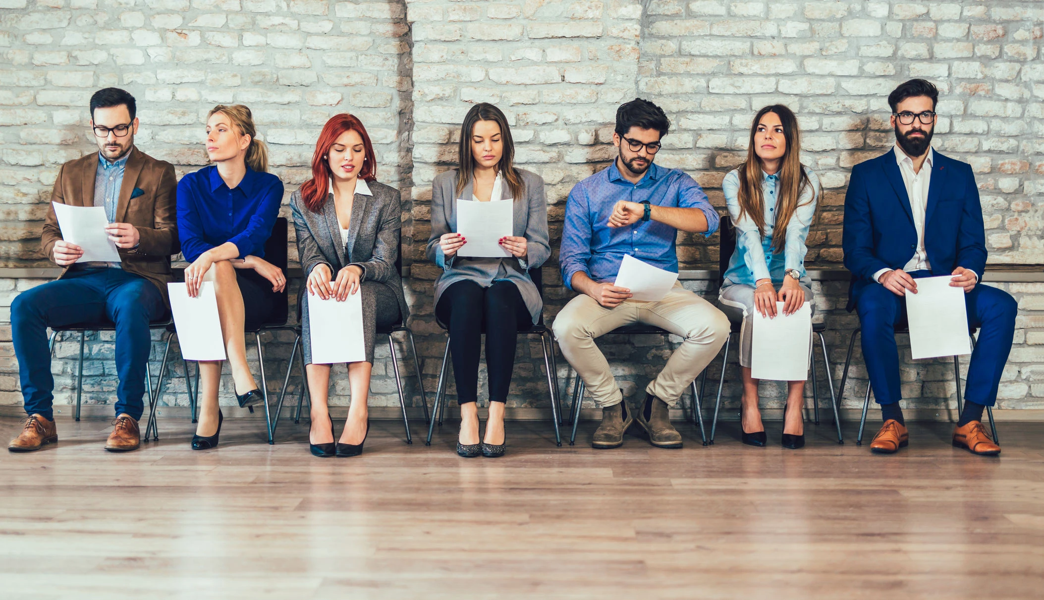 Menschen sitzen auf Stühlen: Was die Sitzposition über Ihren Charakter aussagt.