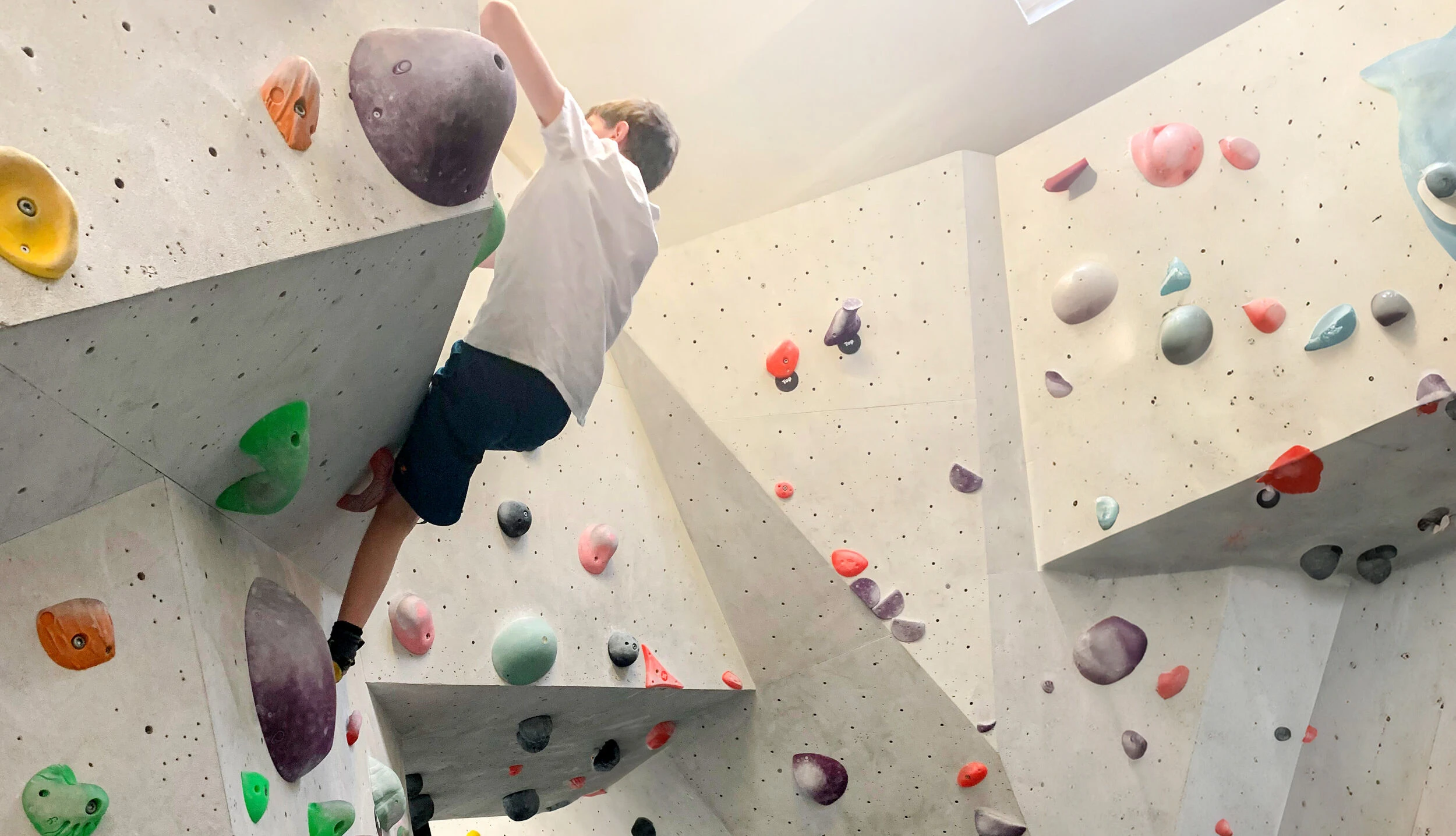 Ein Bub bouldert in einer Halle.
