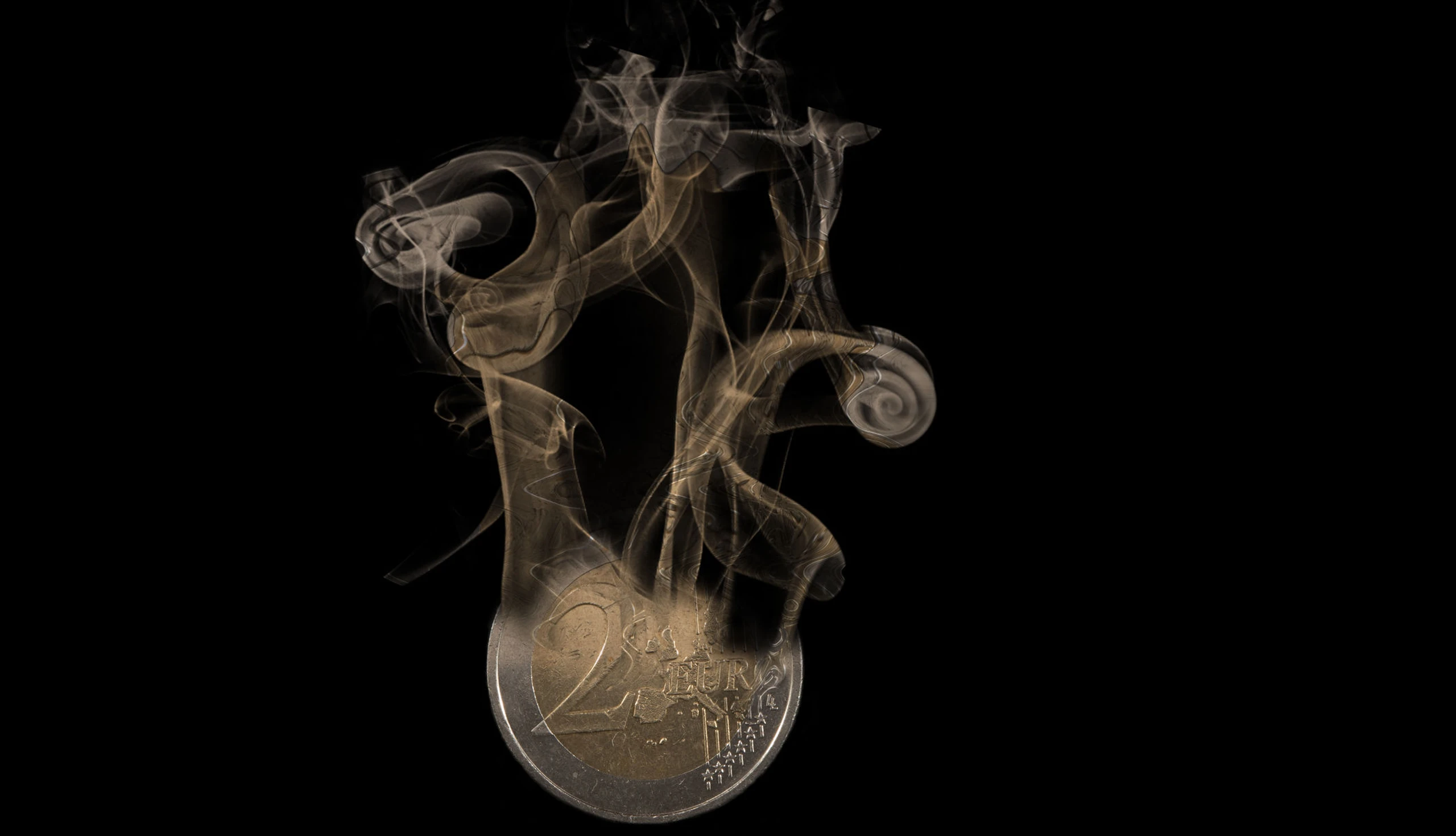 Eine 2-Euro-Münze löst sich auf.