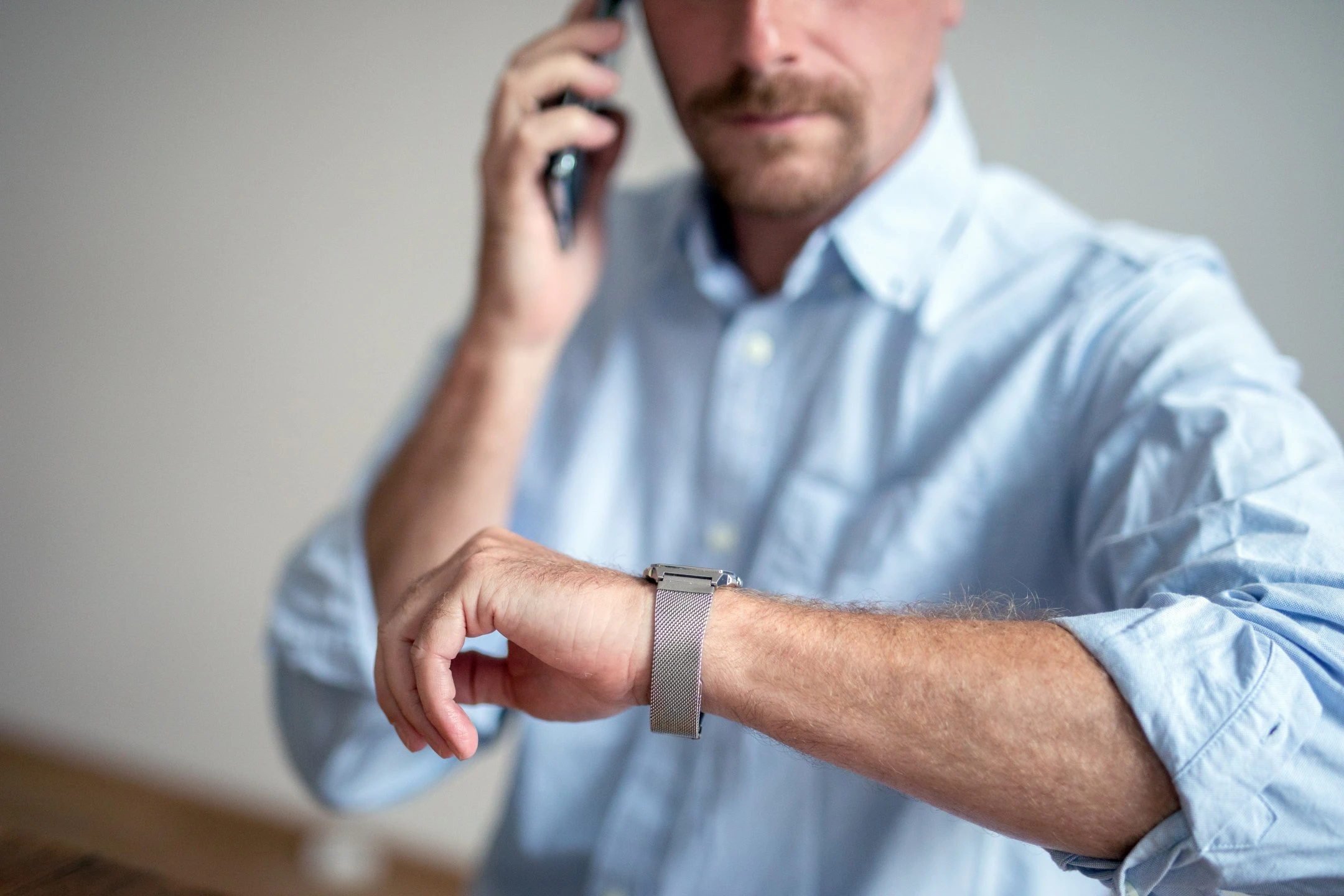 Ein Mann sieht auf seine Uhr.