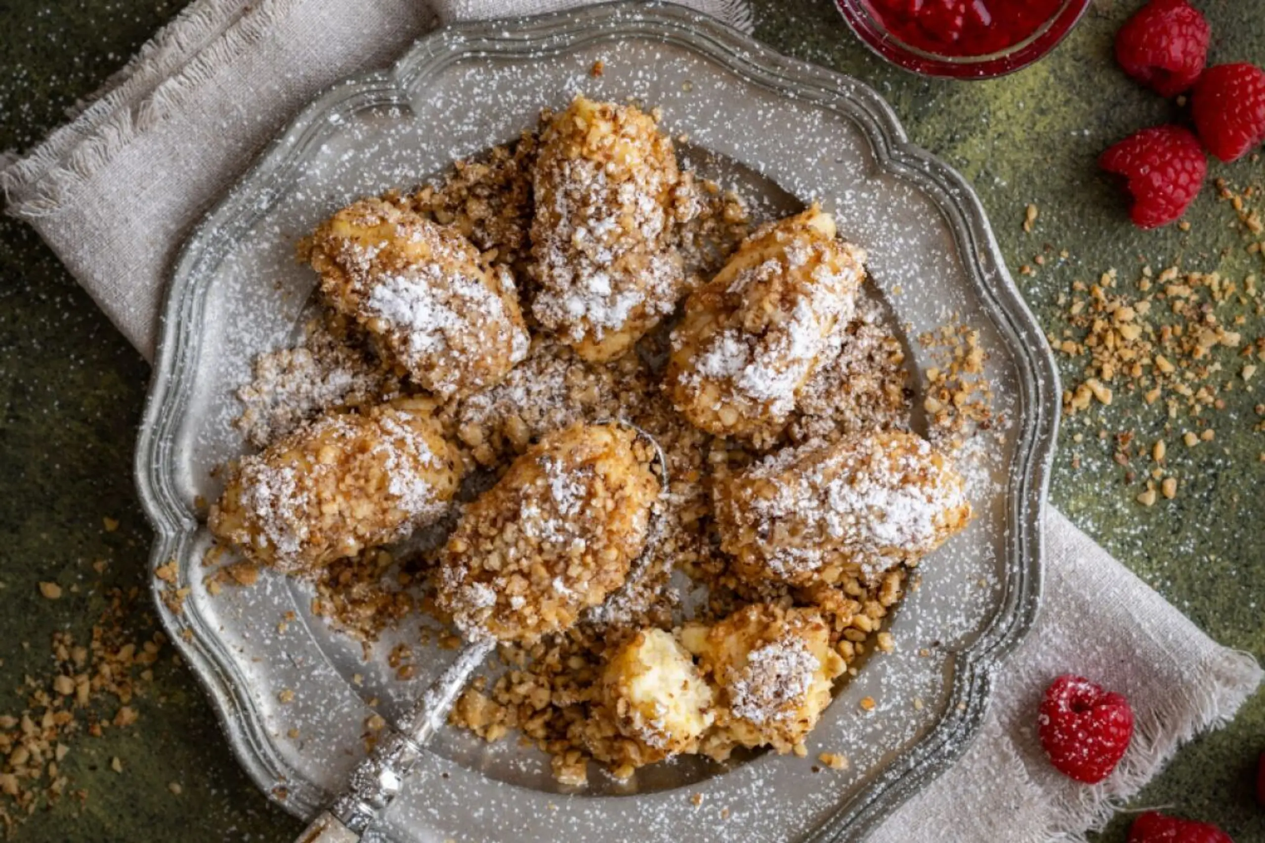 Die Topfennockerln werden mit Zimt und Staubzucker bestäubt und in gerösteten Nüssen gewälzt