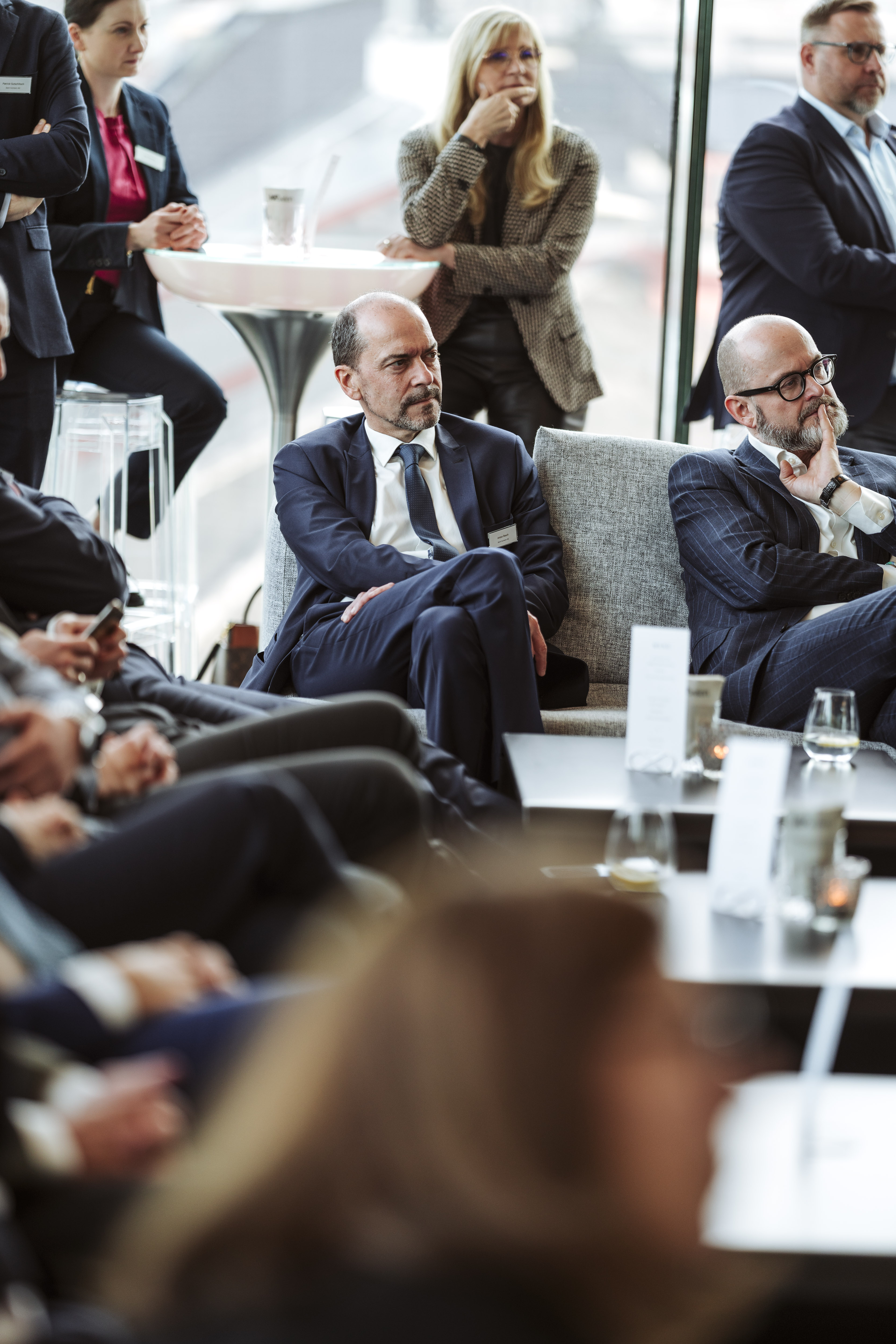 Konferenzfoto: Geschäftsleute in Anzügen sitzen an Tischen und diskutieren. Fotografin: Nadine Studeny (nadine-studeny.at)