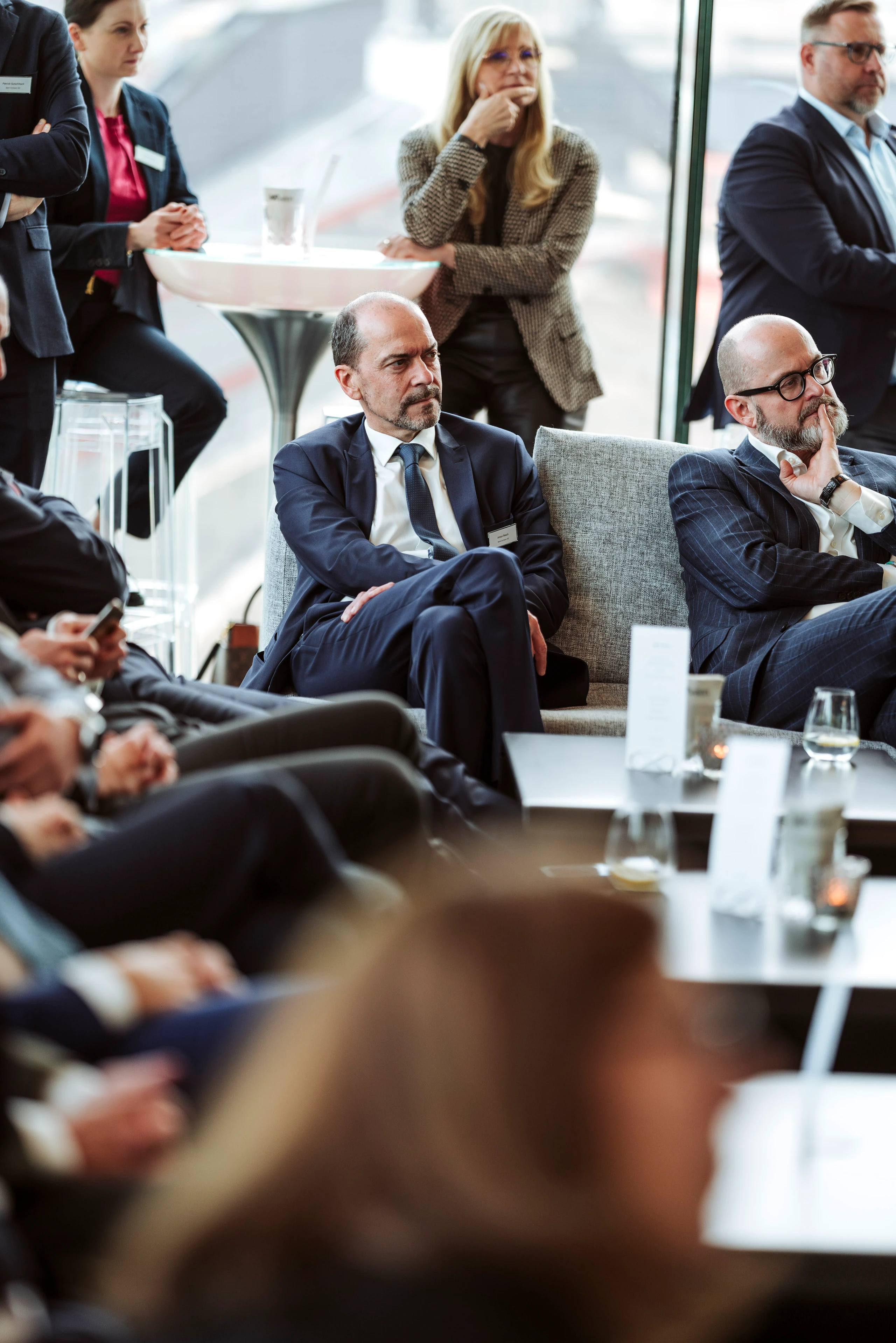 Konferenzfoto: Geschäftsleute in Anzügen sitzen an Tischen und diskutieren. Fotografin: Nadine Studeny (nadine-studeny.at)