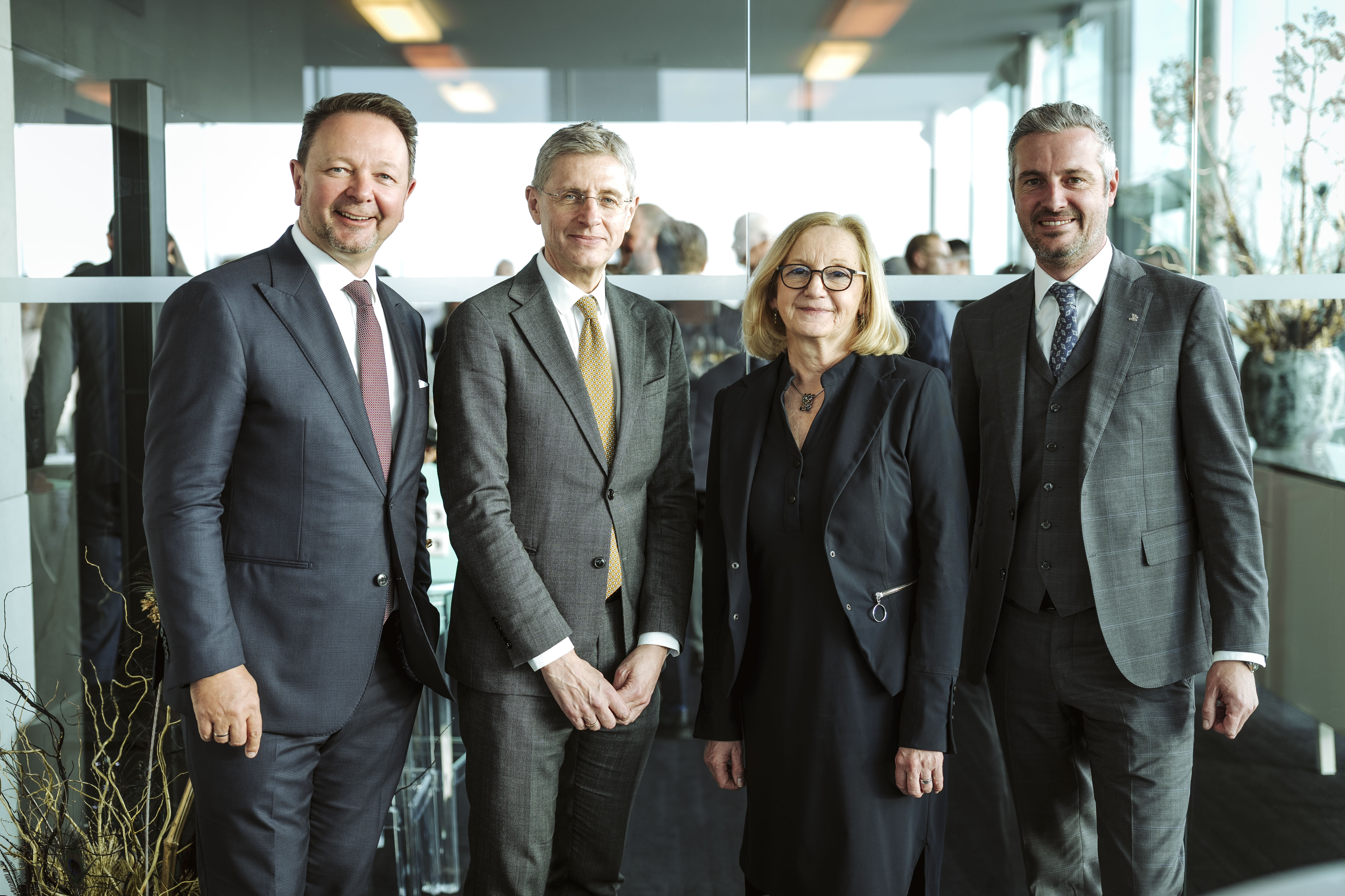 Foto von vier Geschäftsleuten in Anzügen.  Aufgenommen von Nadine Studeny mit Adobe Photoshop Lightroom Classic.