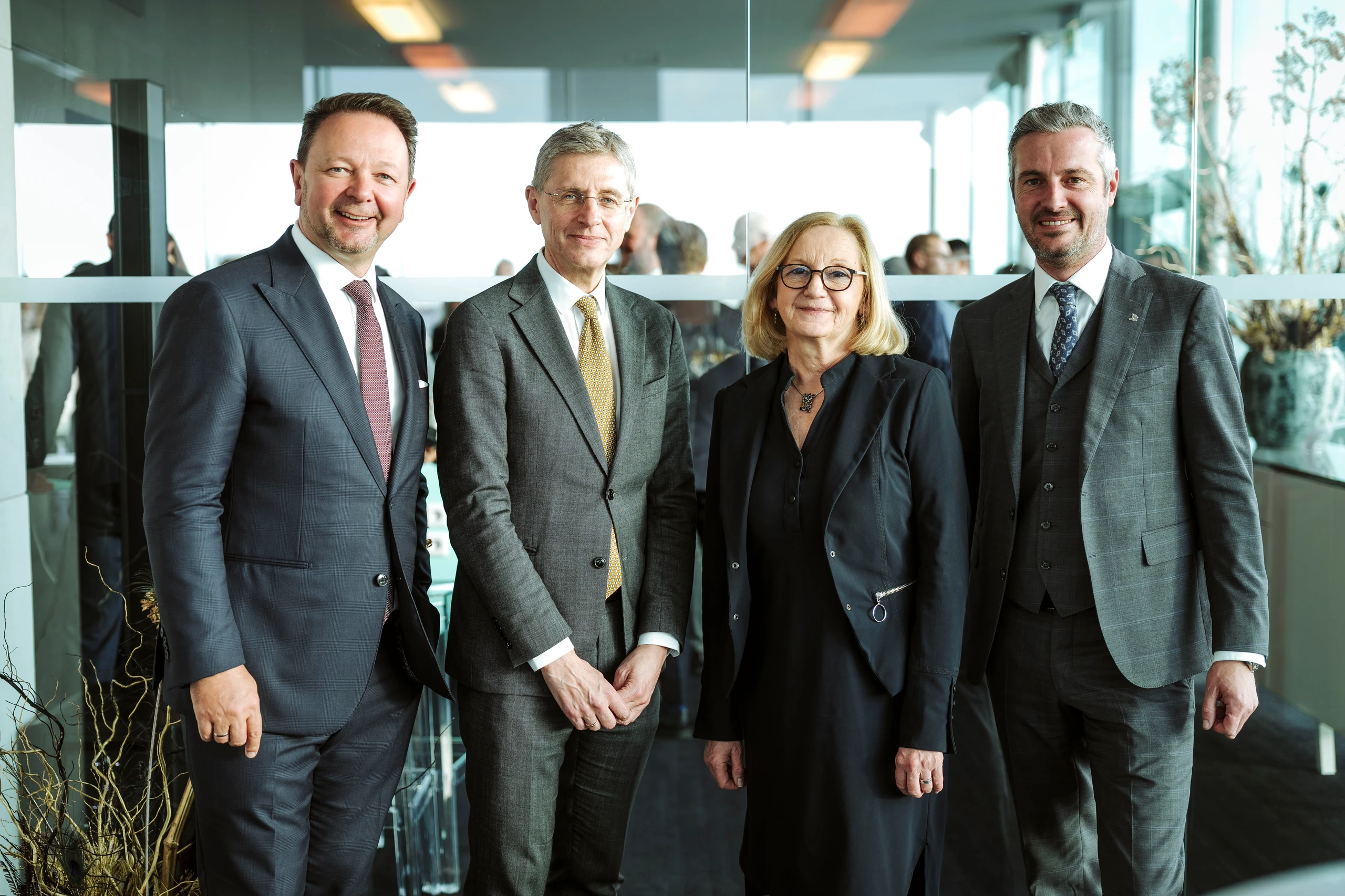 Foto von vier Geschäftsleuten in Anzügen.  Aufgenommen von Nadine Studeny mit Adobe Photoshop Lightroom Classic.