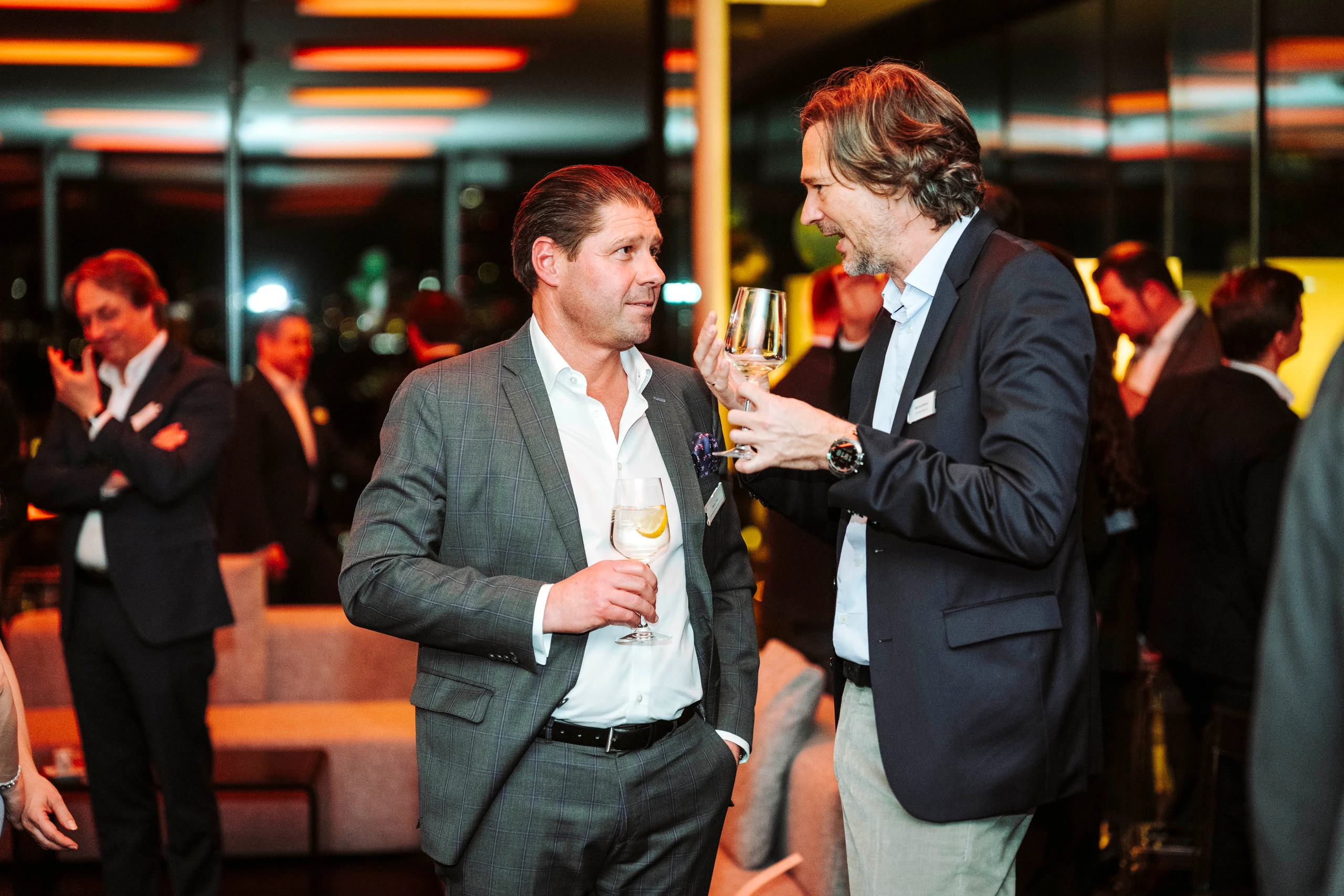 Zwei Geschäftsmänner unterhalten sich auf einer Veranstaltung. Foto von Nadine Studeny.