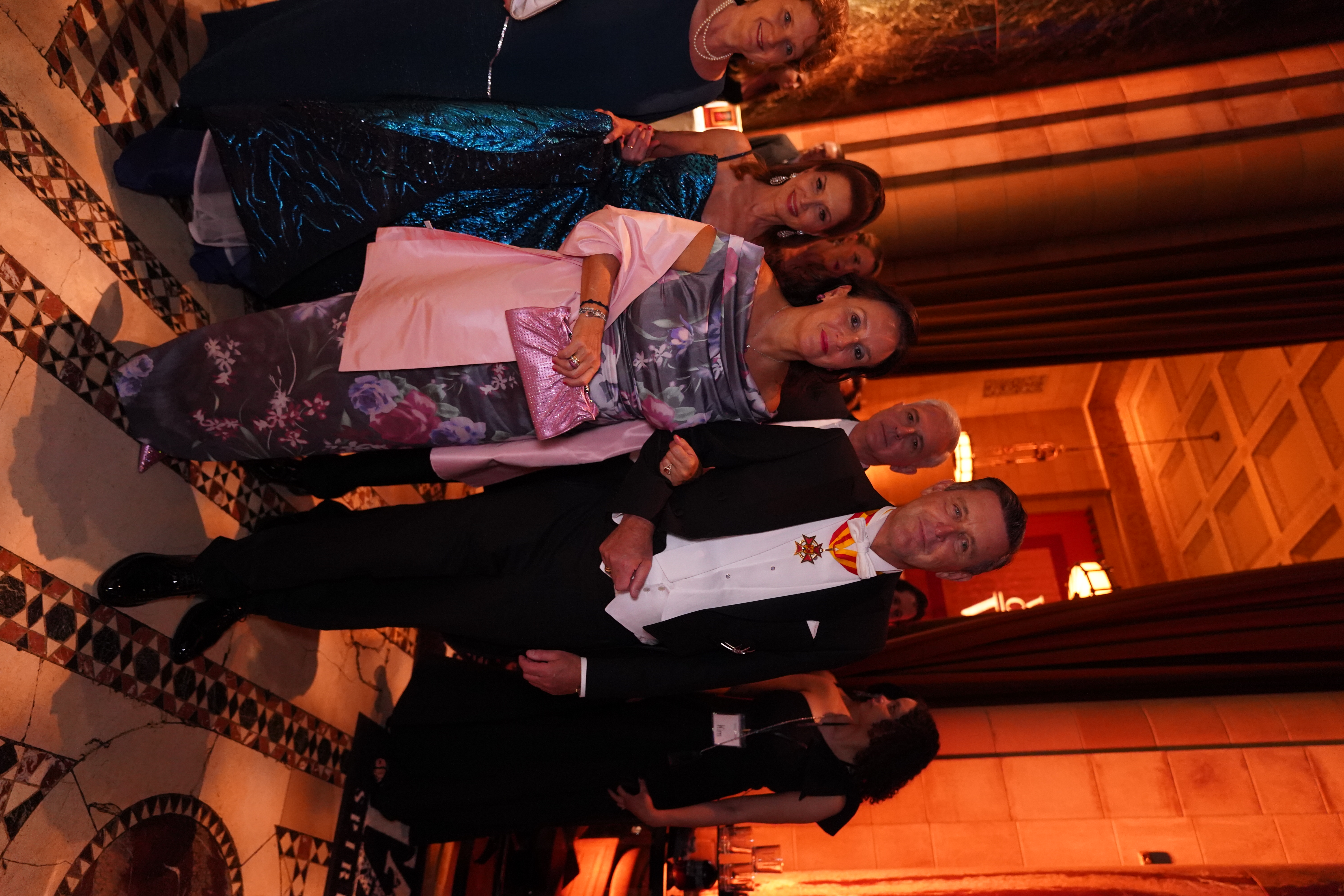 Elegant gekleidete Gäste auf einer formellen Gala. Abendkleider, Smokings und festliche Atmosphäre.