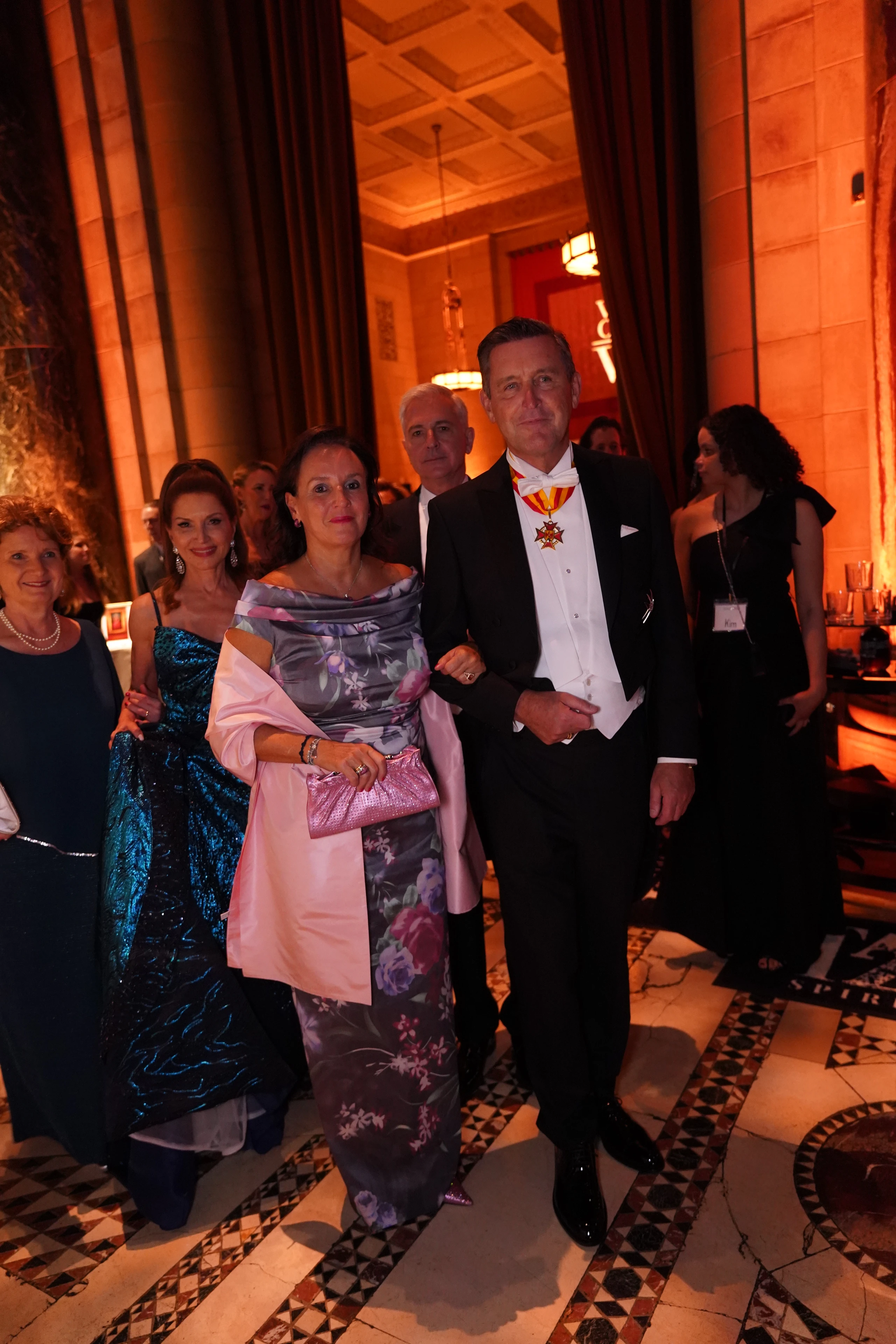 Elegant gekleidete Gäste auf einer formellen Gala. Abendkleider, Smokings und festliche Atmosphäre.