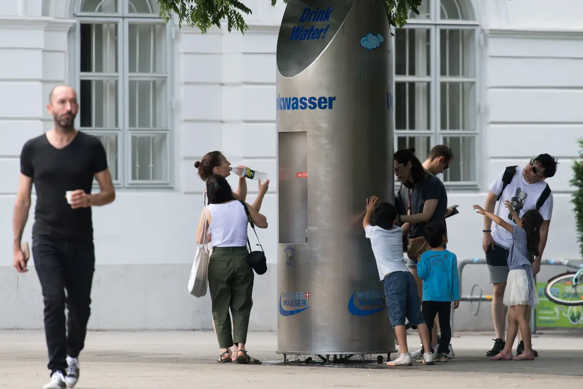 Kinder und Erwachsene holen sich an einem Trinkbrunnen in Wien Wasser
