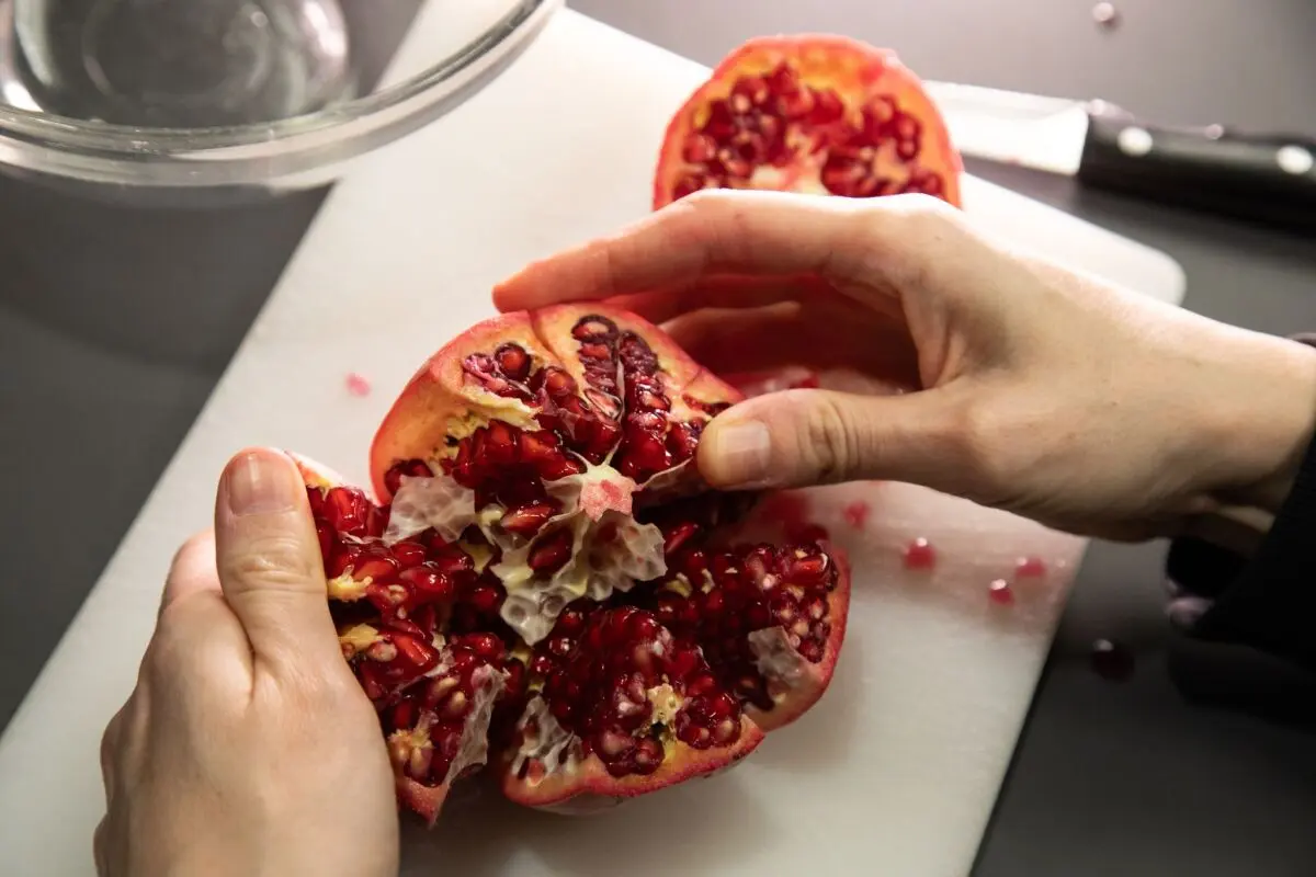 Den Granatapfel auseinanderziehen und öffnen