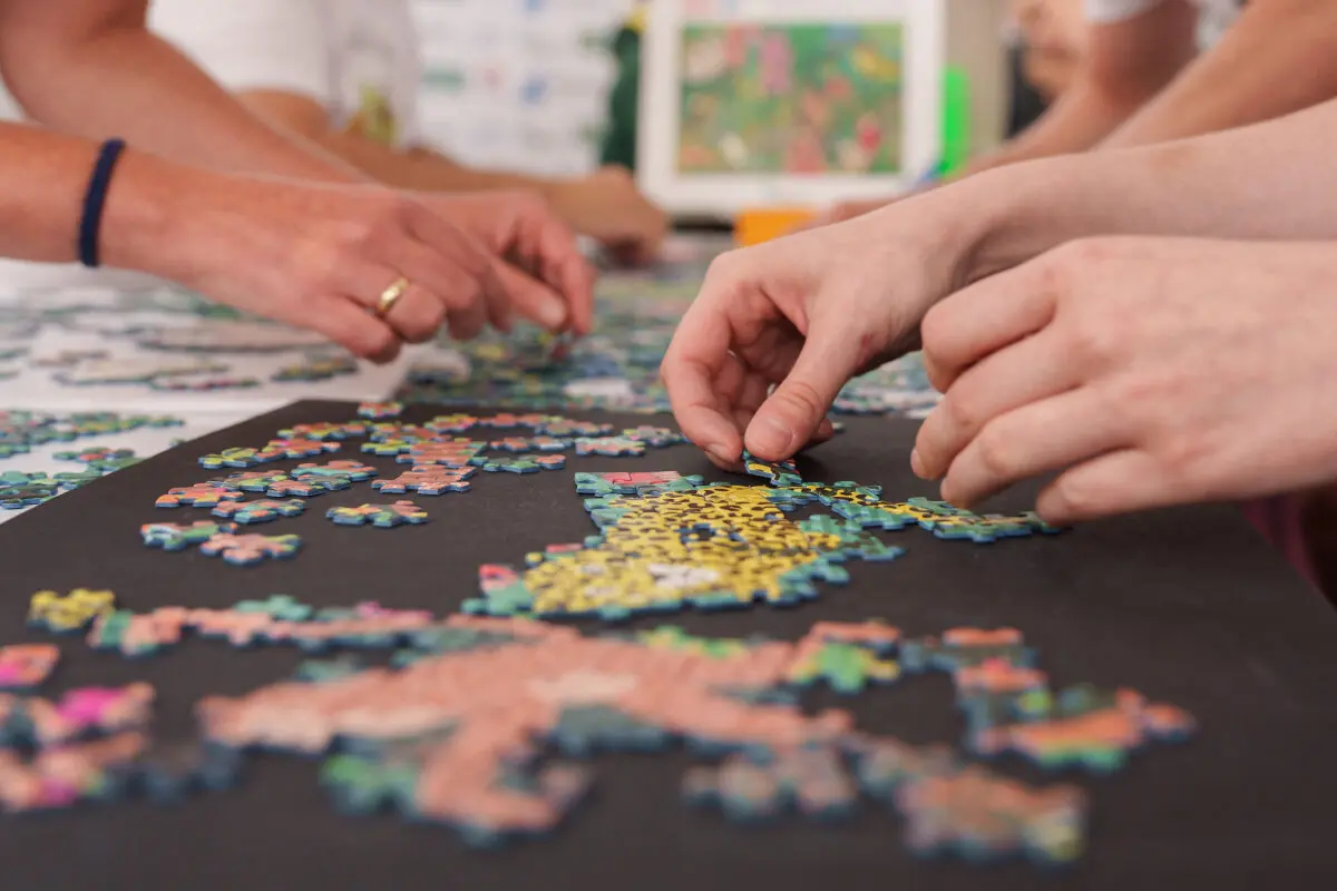 Nach dem gemeinsamen Puzzeln bewegen sich zwei Personen synchron