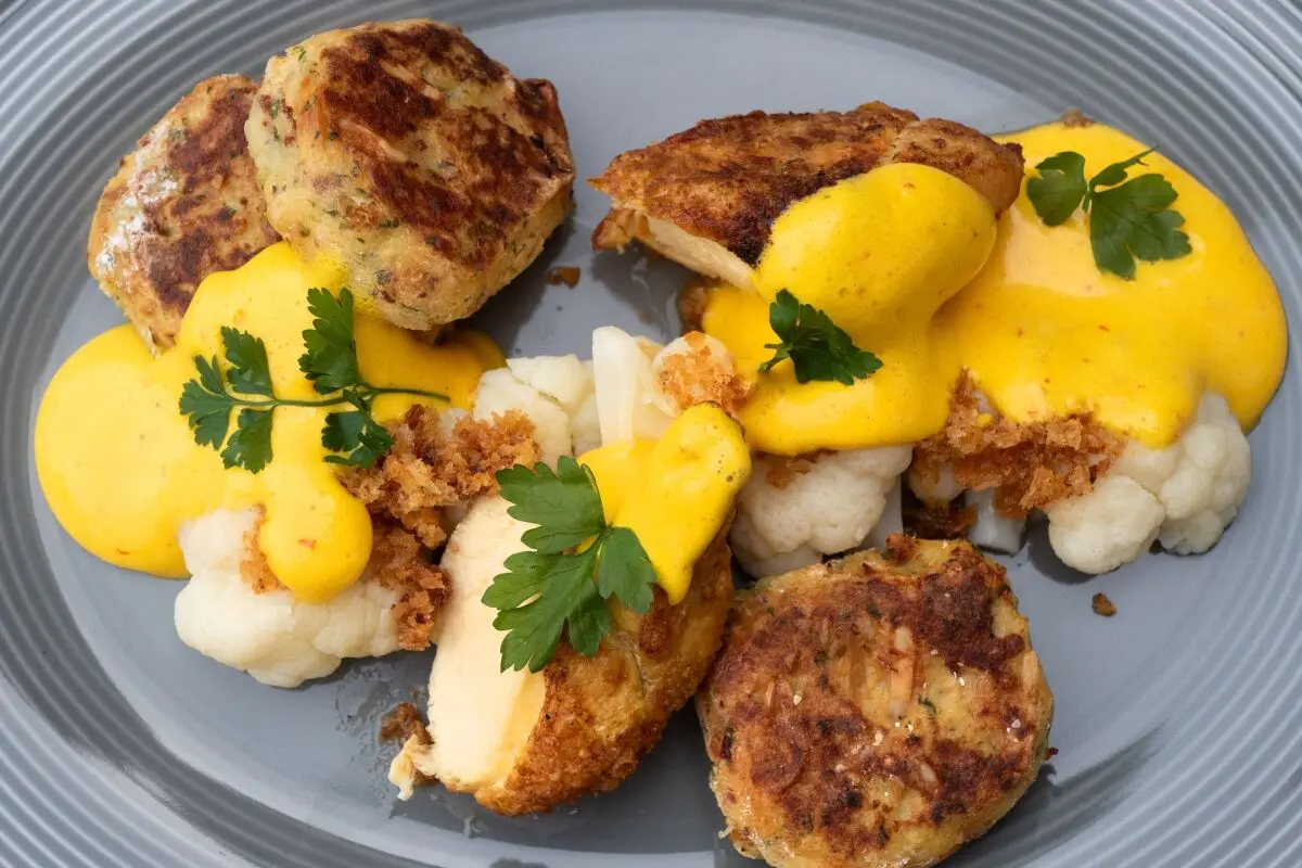 Leuchtend gelbe Safran-Kardamom-Sauce setzt die Hühnerbrust in Szene