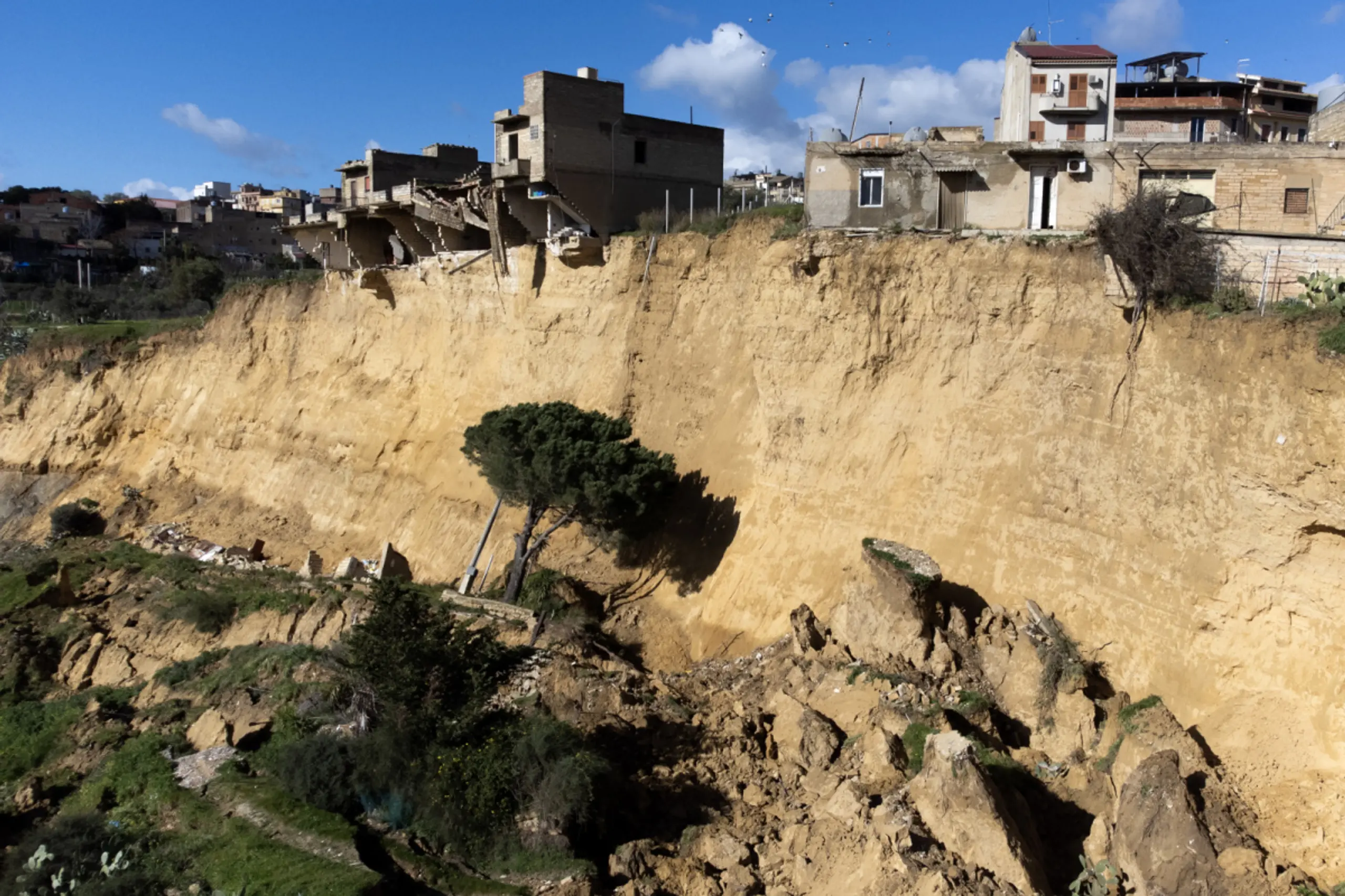 Ein Teil des bereits abgerutschten Hügels mit Häusern am Abhang