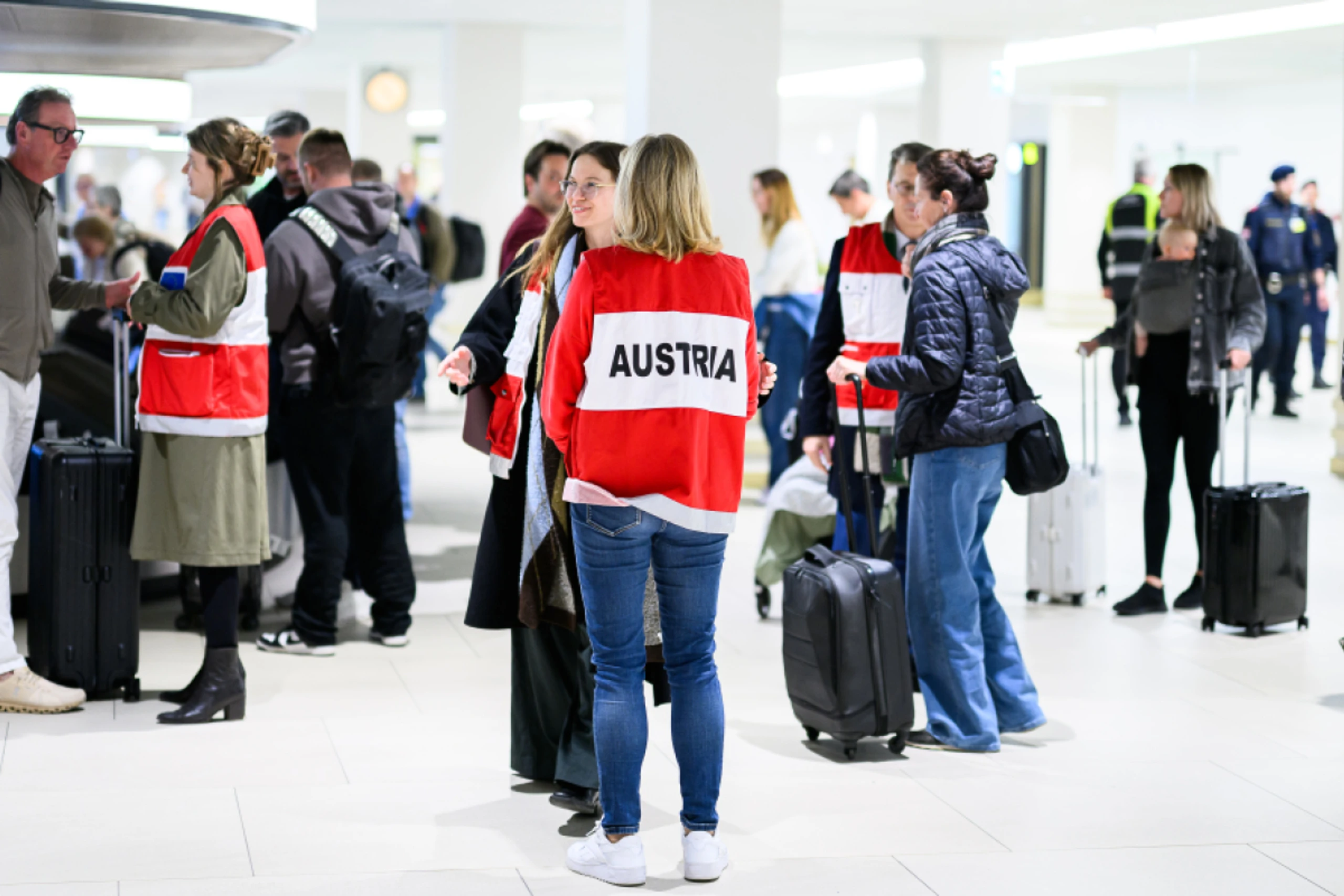 Außenministerin Meinl-Reisinger (M.) mit den angekommenen Fluggästen