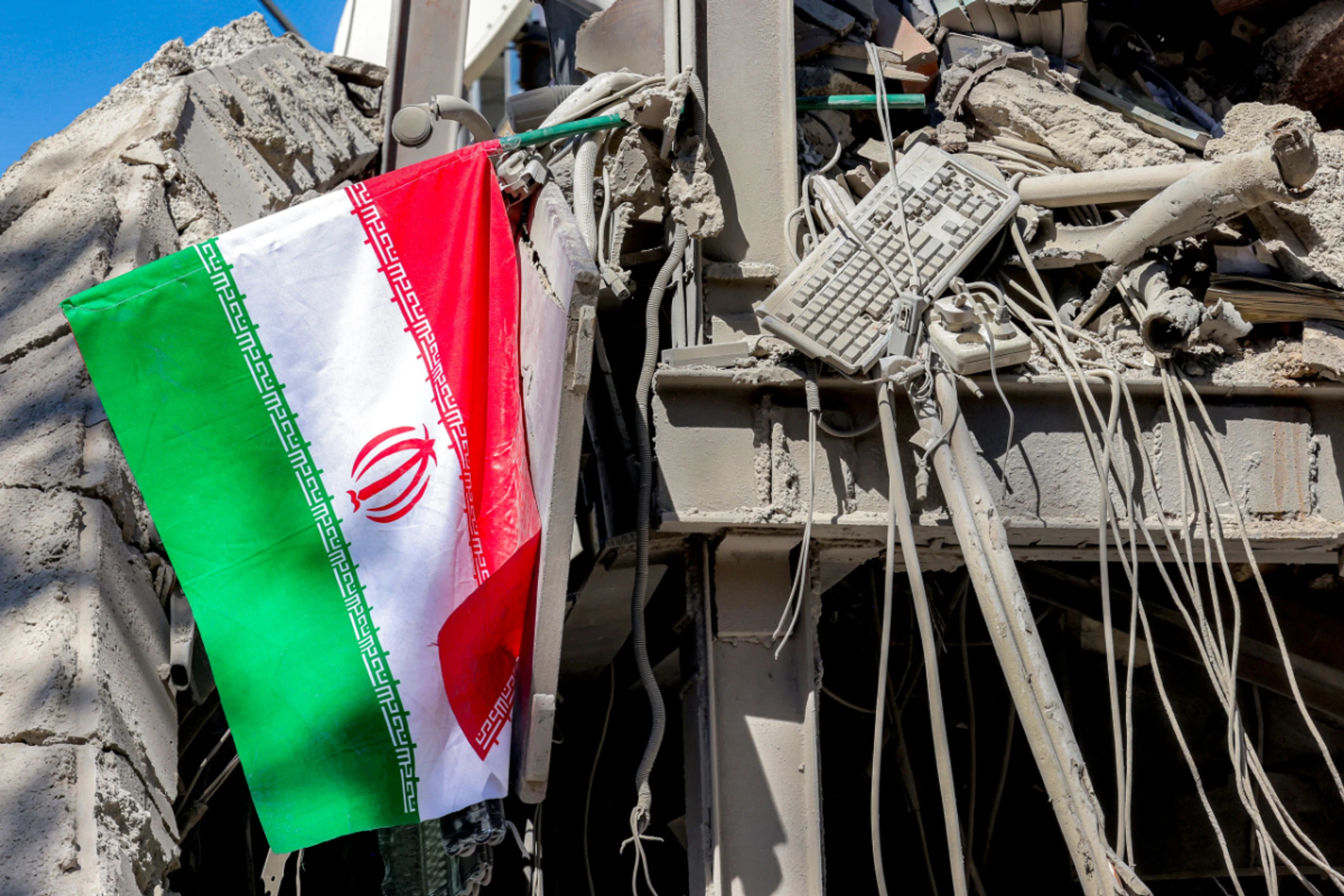 Eine iranische Flagge auf einem zerstörten Gebäude in Teheran