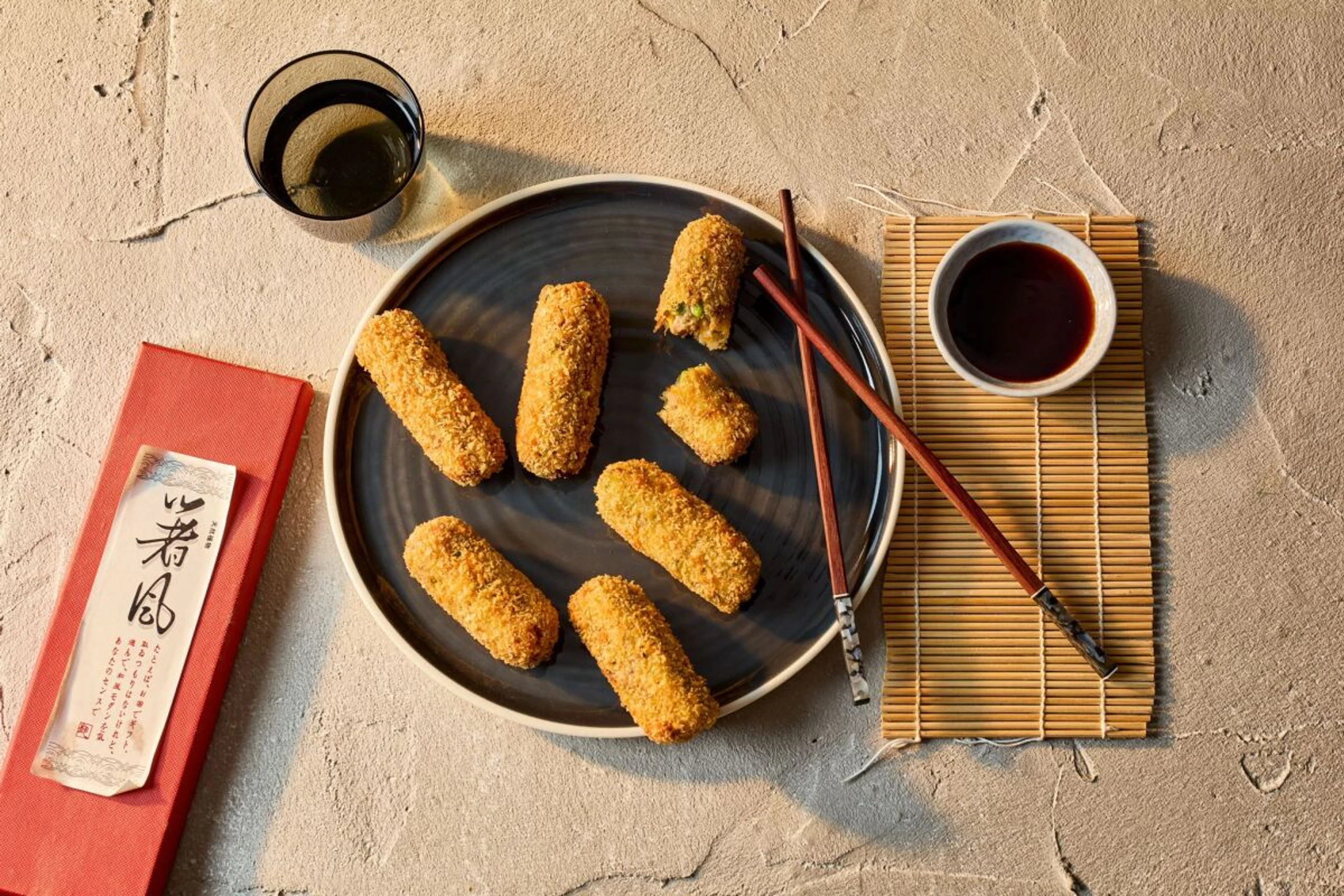 Japanische Korokke werden in eine süß-würzige Tonkatsusoße gedippt