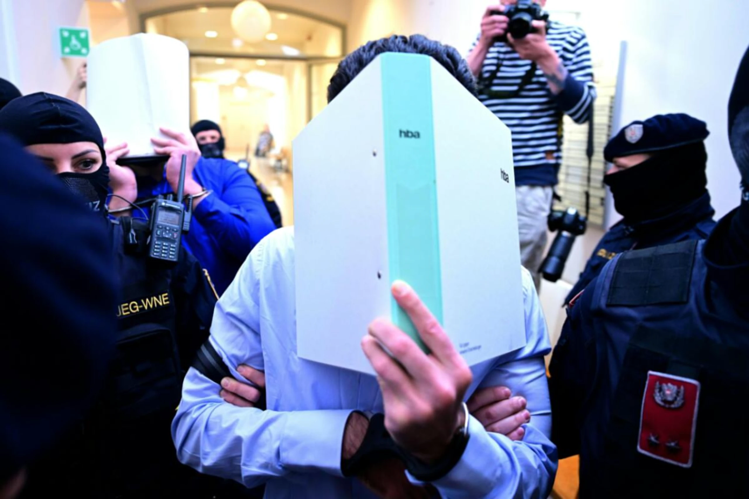 Die Angeklagten verbargen ihre Gesichter vor den Fotografen