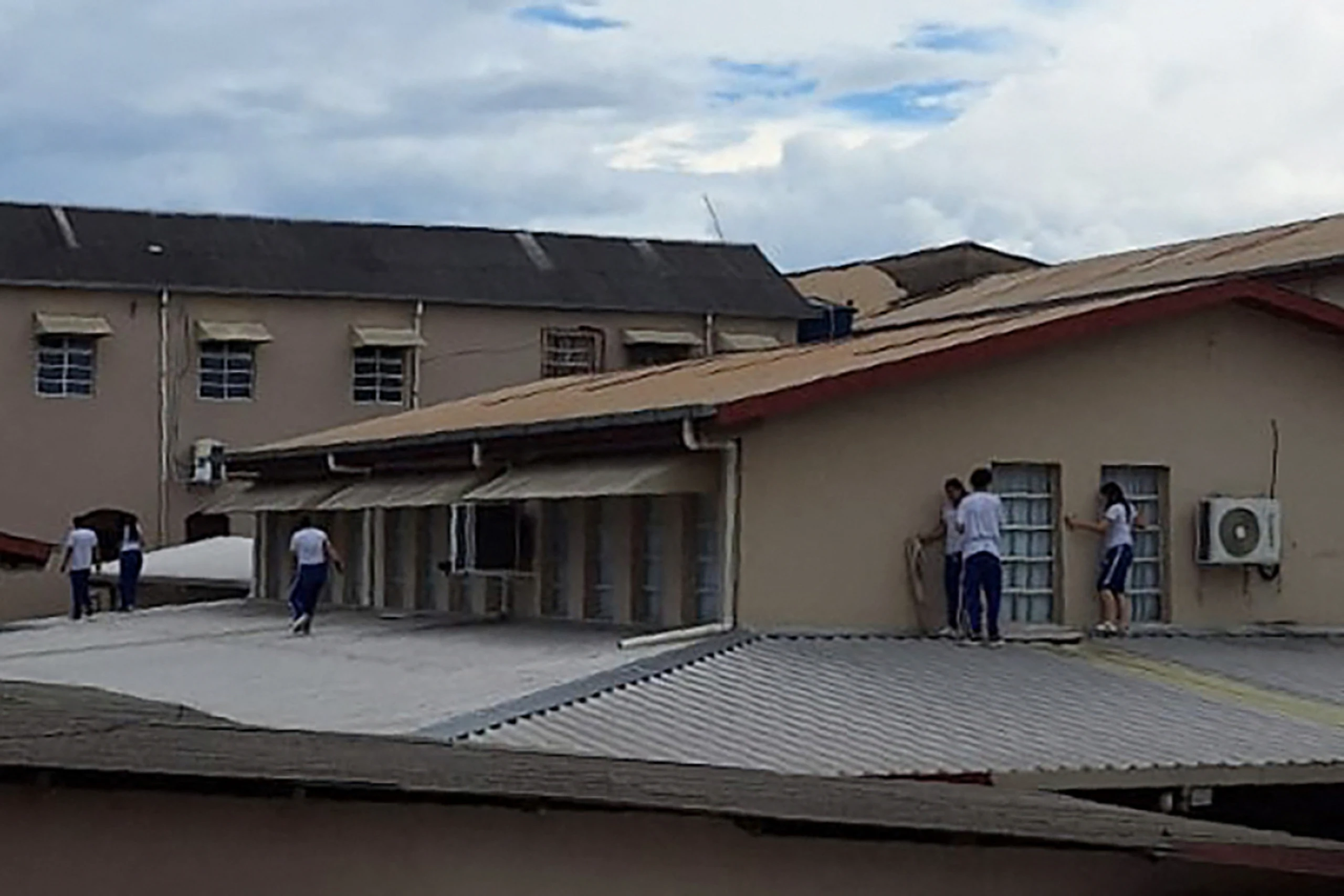 Schülerinnen und Schüler suchen auf dem Dach der Schule Deckung