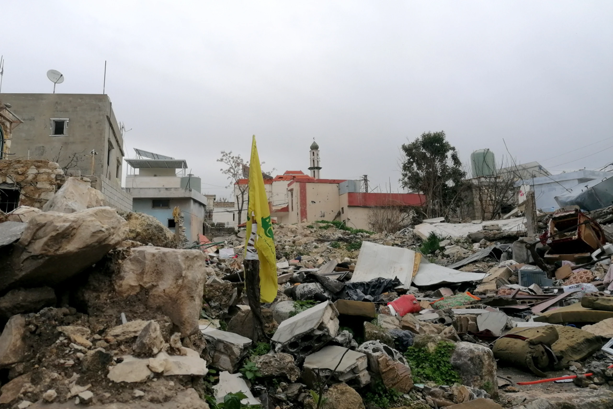 Hisbollah Flagge inmitten zerstörter Gebäude im Südlibanon