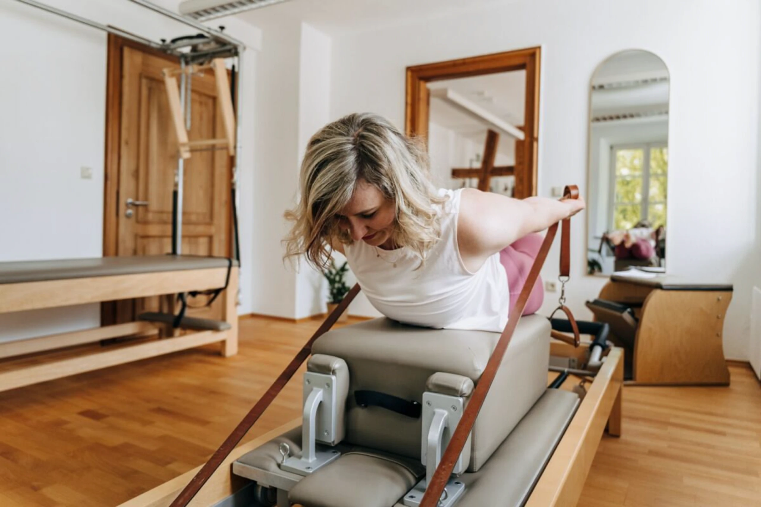 Beim Reformer-Pilates führt man Übungen auf einem speziellen Gerät aus