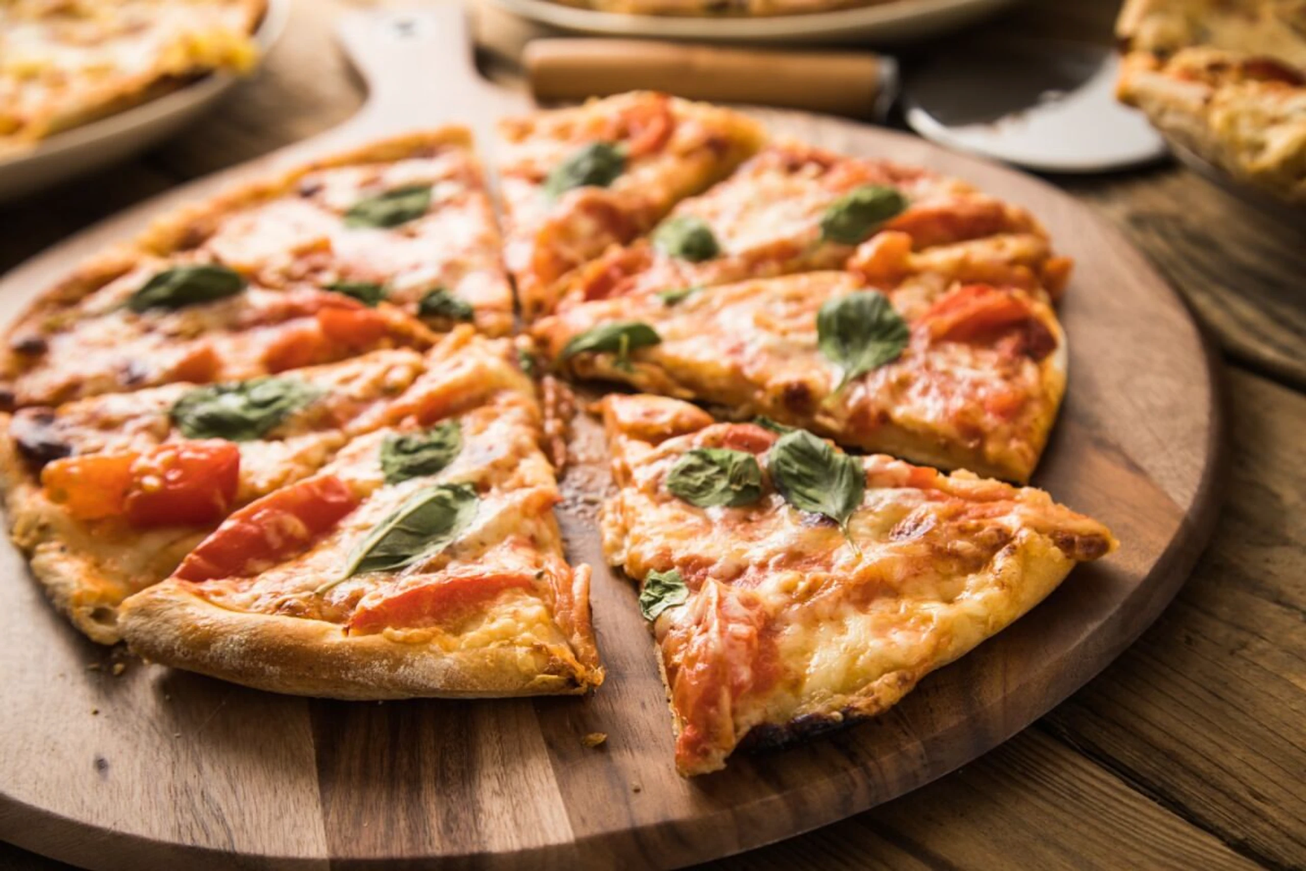 Eine Tiefkühlpizza kann man mit Gemüse und Mozzarella aufwerten