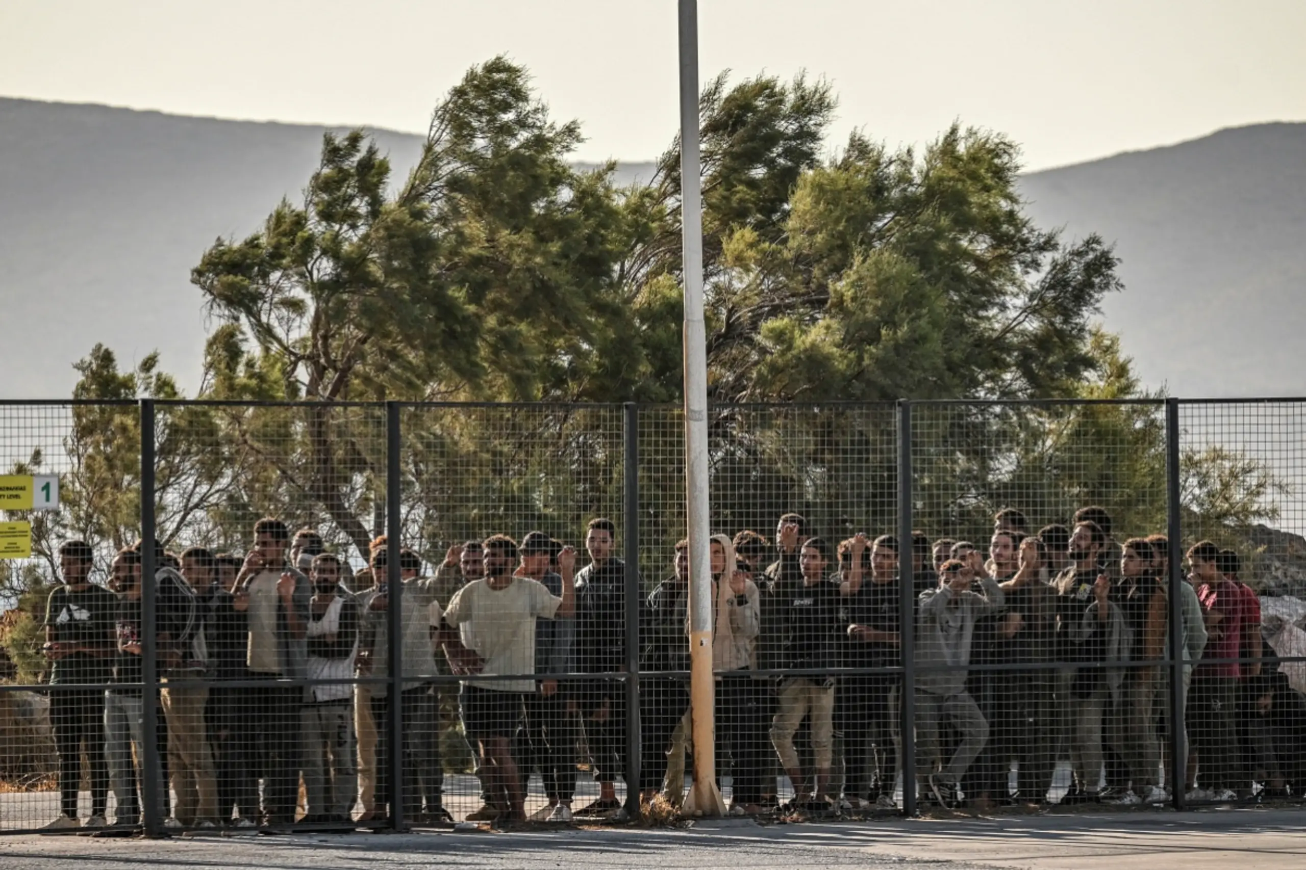 Migranten hinter einen Zaun in Griechenland