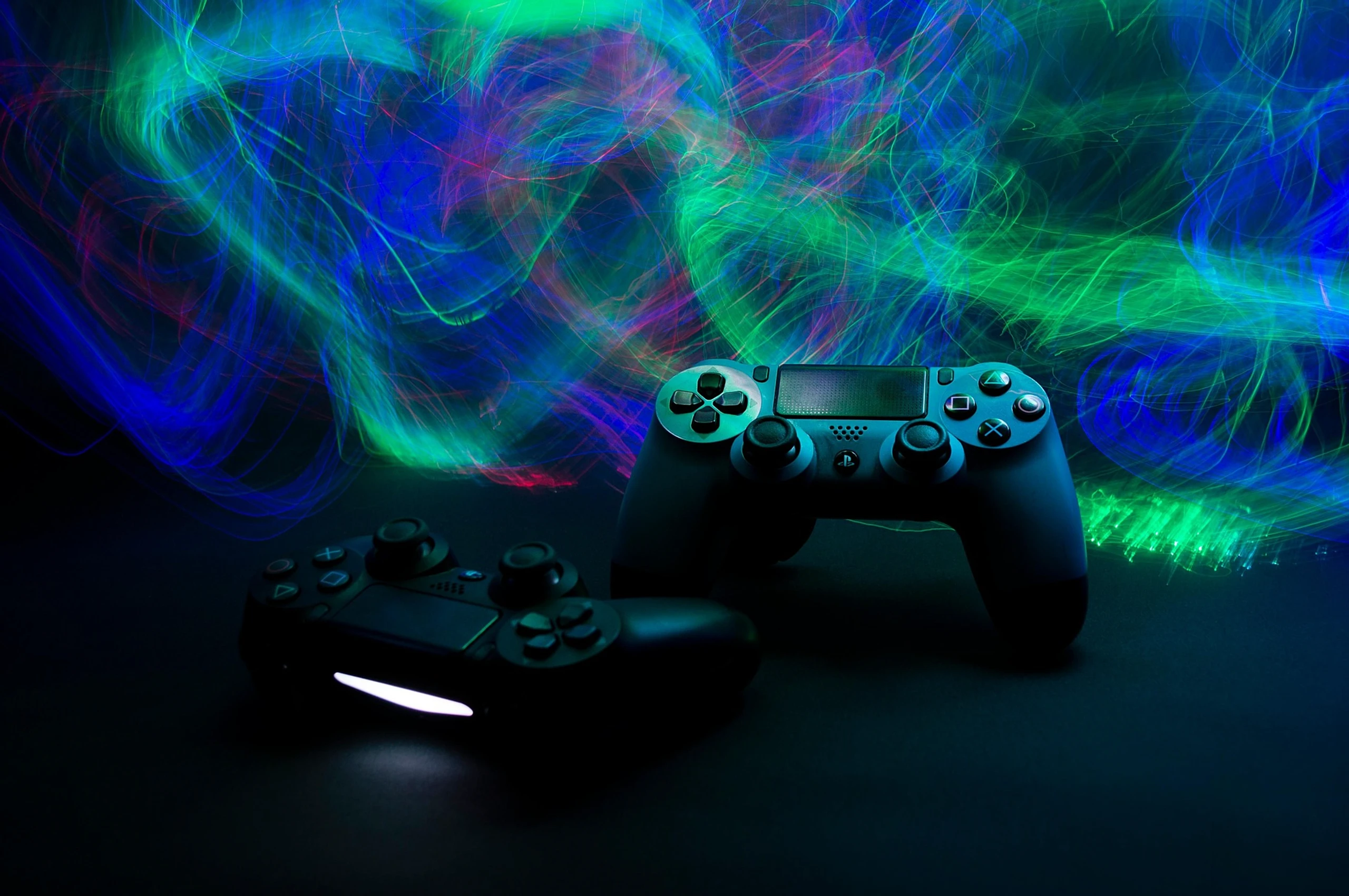 Zwei Gamecontroller im Neonlicht vor dunklem Hintergrund