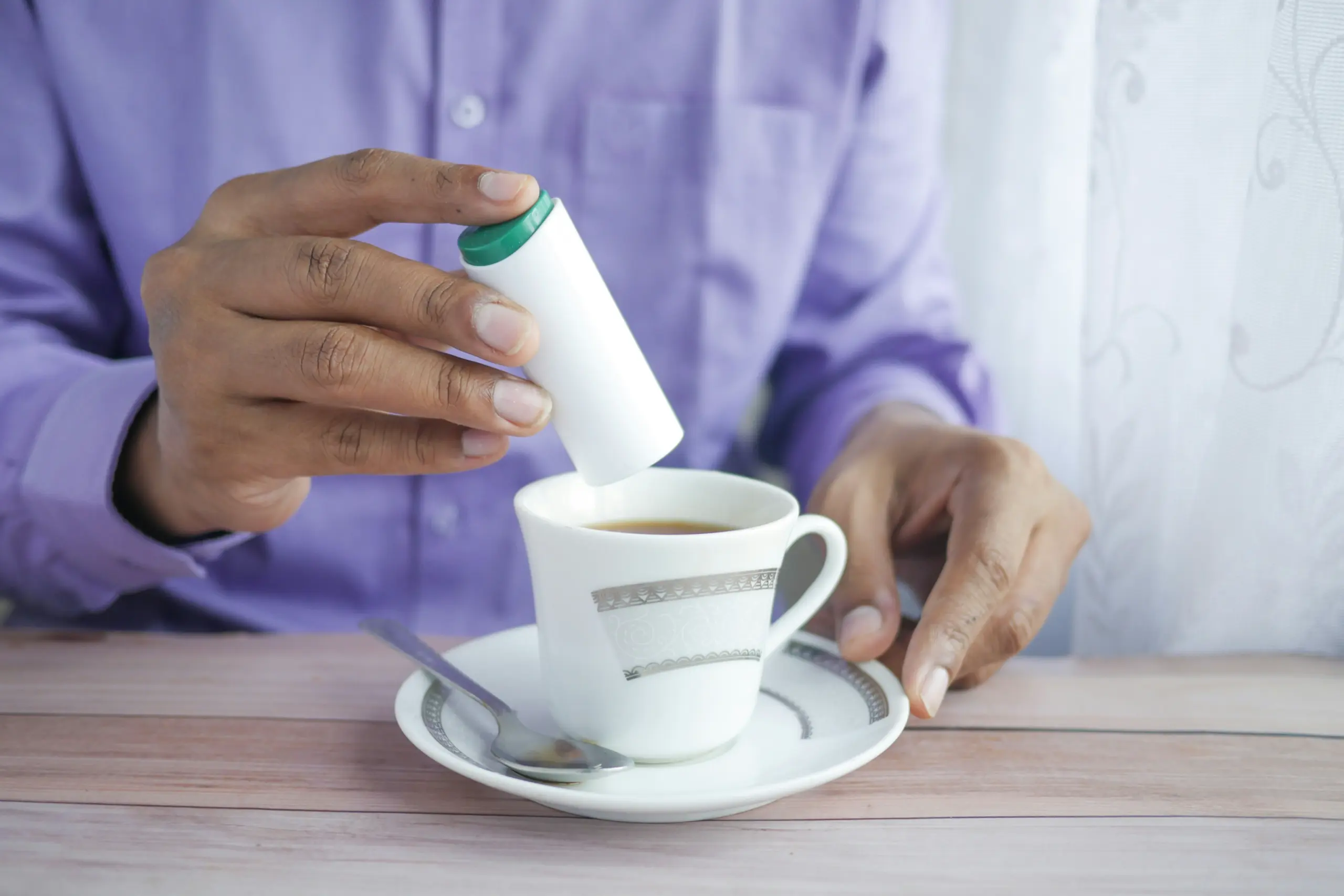 Person hält eine weiße Tasse in den Händen