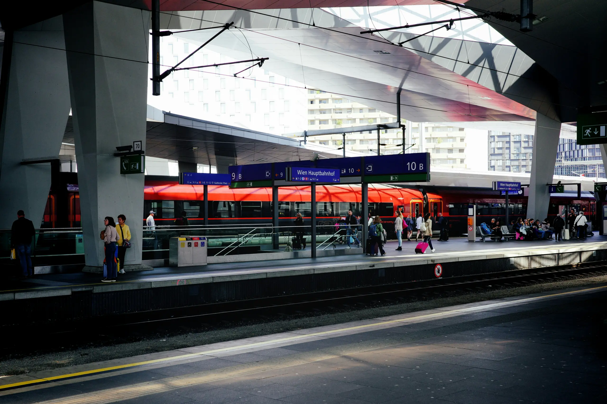 Fahrgäste warten am Bahnsteig auf einen Zug