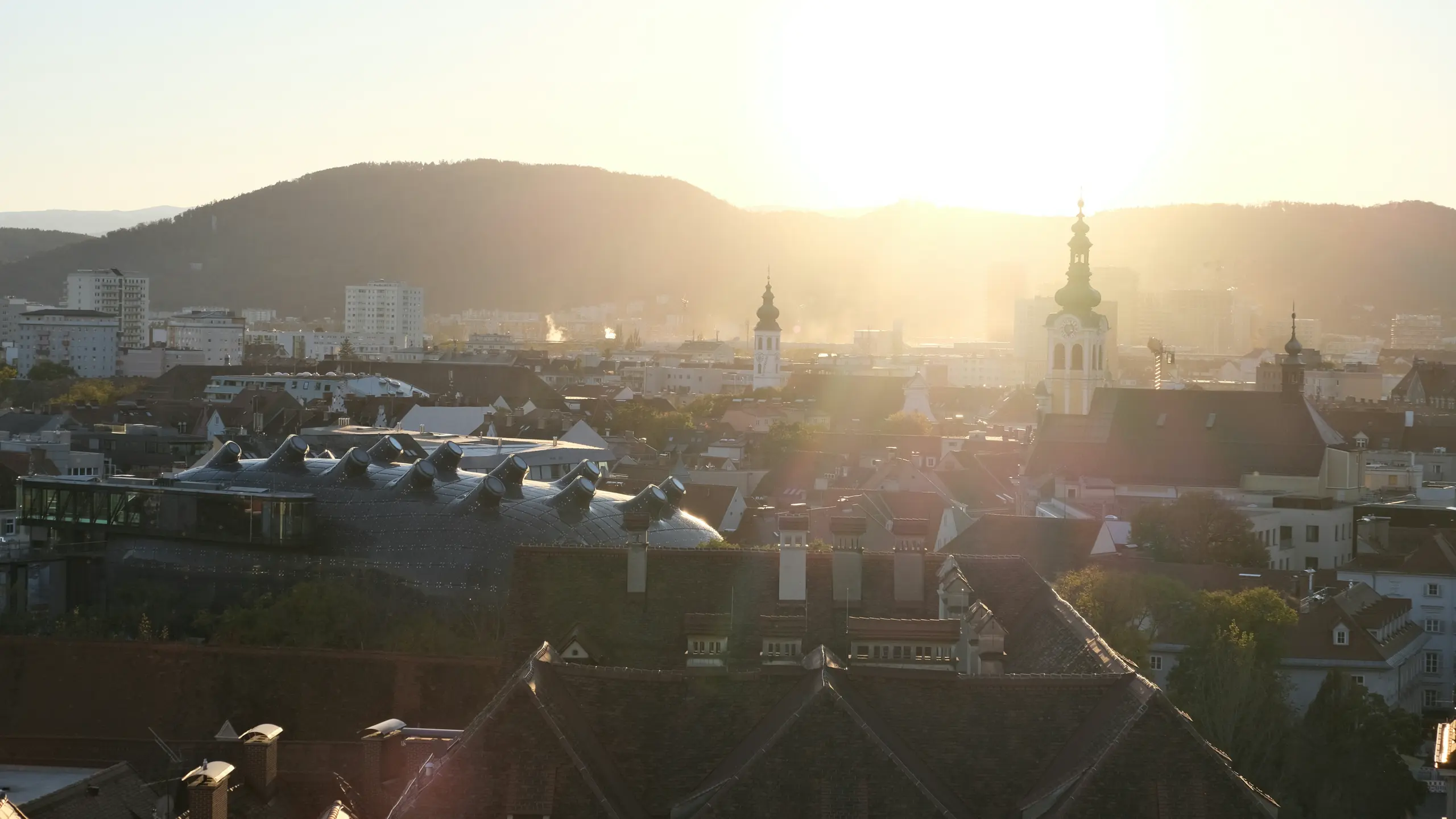 Abendstimmung über Graz mit Bergen im Hintergrund