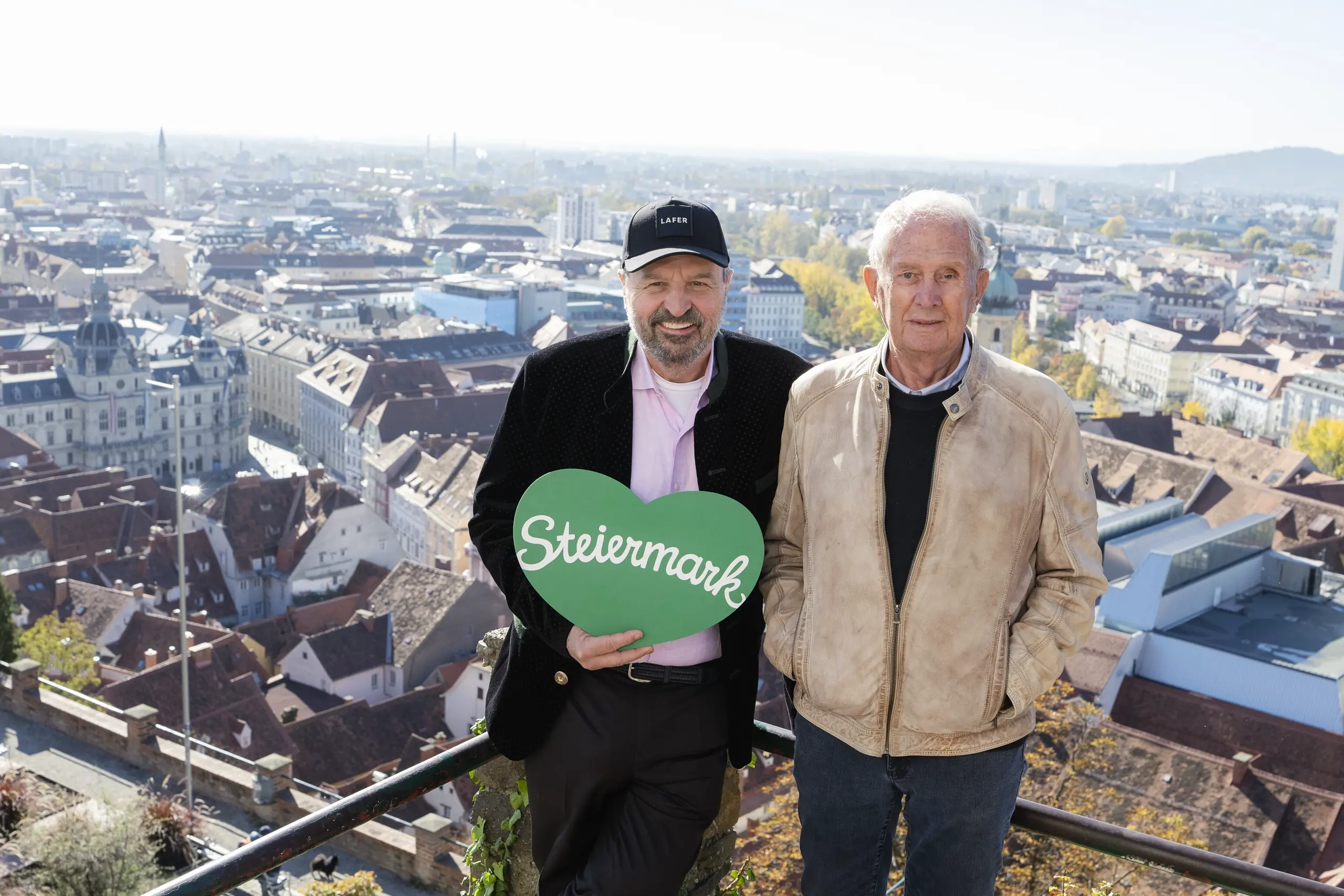 Johann Lafer und Helmut Marko am Grazer Schlossberg mit Blick über Graz