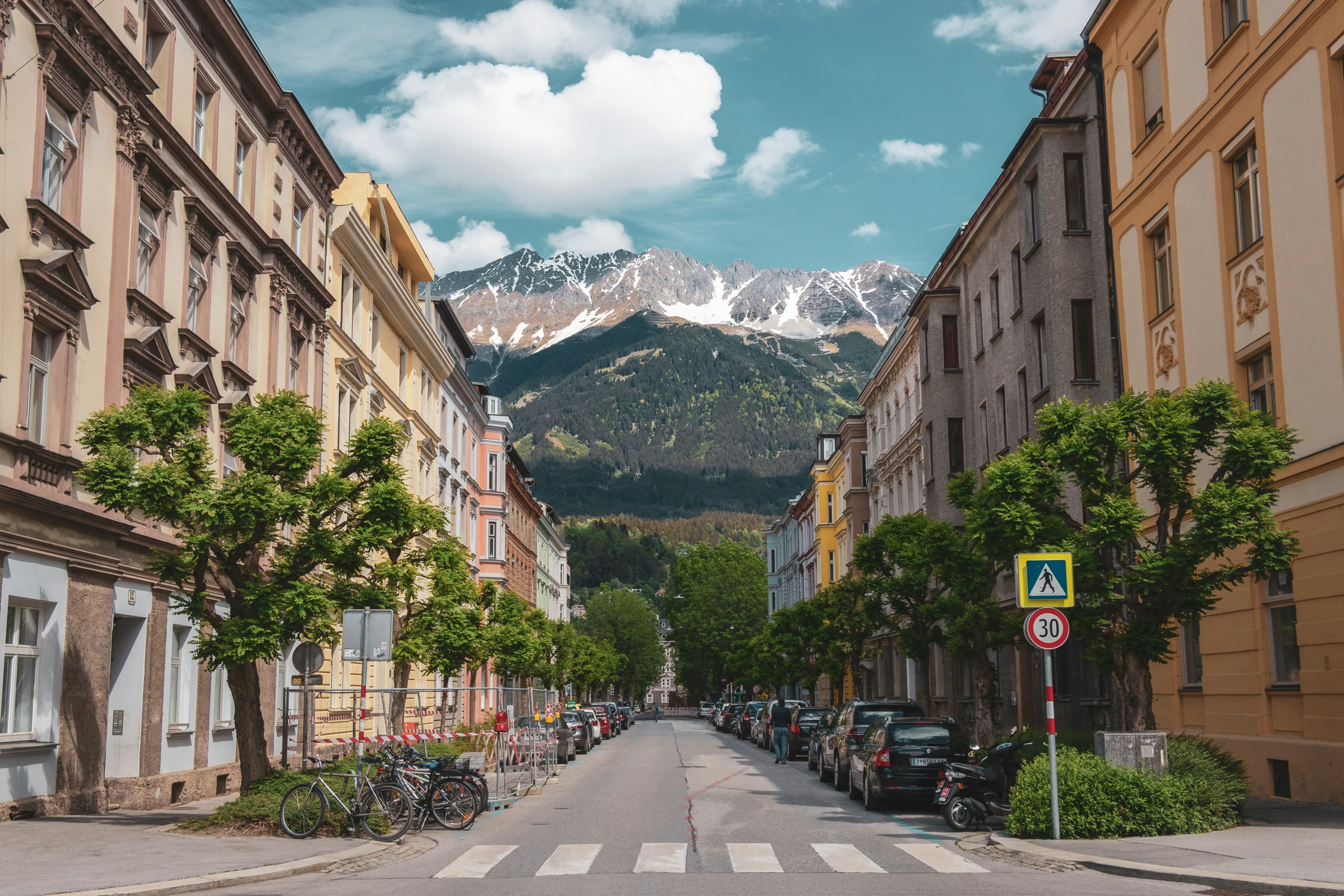 Geparkte Autos in einer Wohnstraße in Innsbruck, im Hintergrund die Nordkette