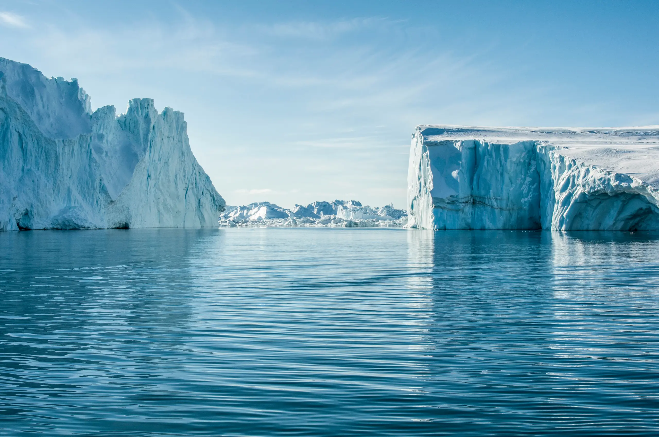 Eisberge im Eisfjord von Ilulissat in Grönland unter blauem Himmel