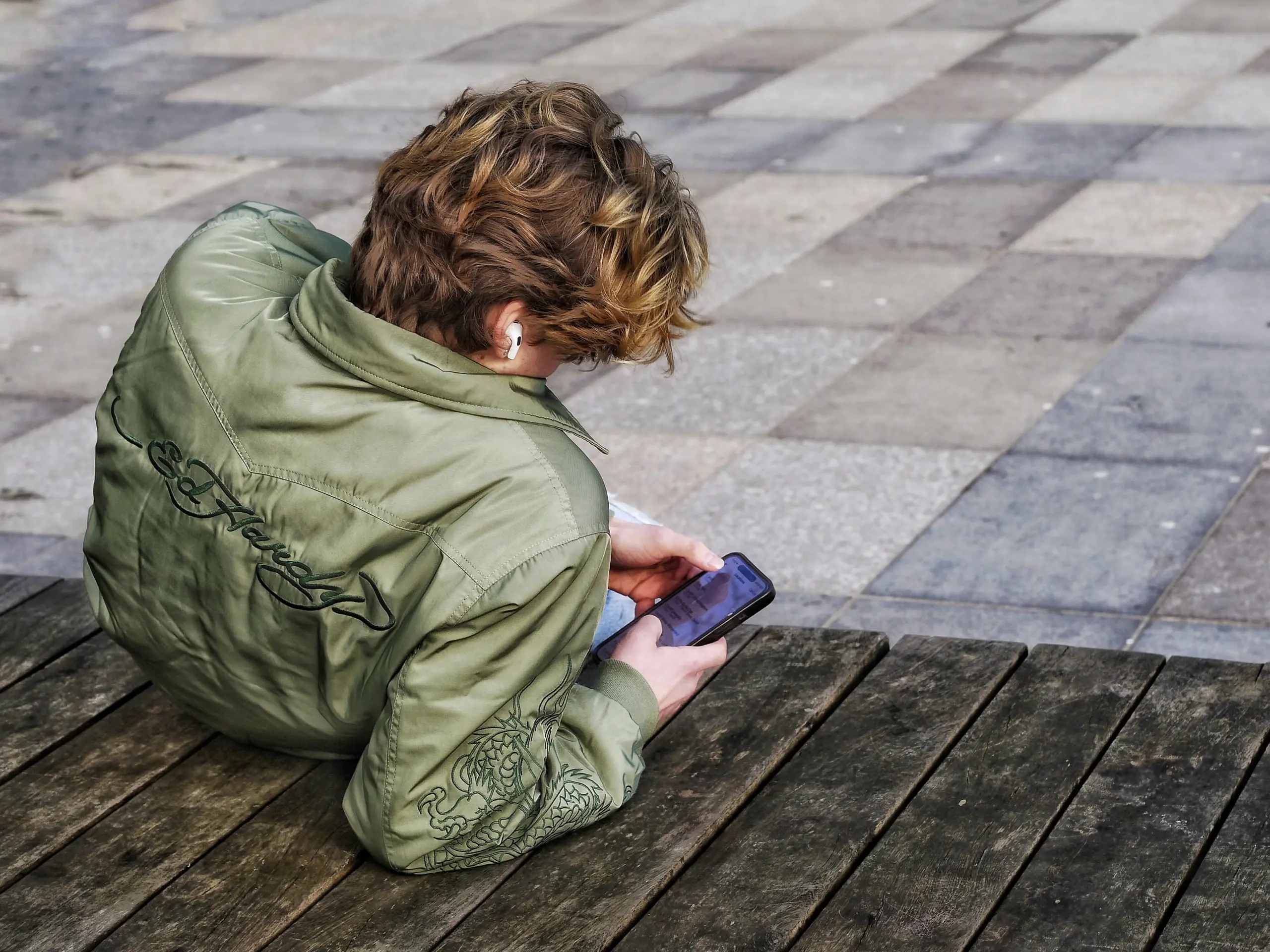 Junge Person schaut auf ein Smartphone